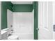 Bathroom featuring a white tiled shower-tub combo, toilet, and green walls at 7023 Hartington Pl, Indianapolis, IN 46259
