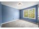 A charming bedroom with gray carpet and a window with view of the outdoors at 7023 Hartington Pl, Indianapolis, IN 46259