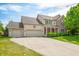 Charming two-story home featuring a three-car garage, red accents, and a well-maintained front lawn at 7023 Hartington Pl, Indianapolis, IN 46259