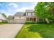 Traditional home with a well-kept lawn, three-car garage, and a welcoming front porch at 7023 Hartington Pl, Indianapolis, IN 46259