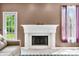 Close-up of the decorative fireplace with white mantel, next to a door and a window at 7023 Hartington Pl, Indianapolis, IN 46259