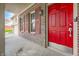 Inviting front porch featuring a vibrant red door, brick accents, and stylish lighting at 7023 Hartington Pl, Indianapolis, IN 46259