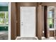 Entryway with a white door and a view into a room with windows and natural light at 7023 Hartington Pl, Indianapolis, IN 46259