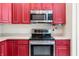 Close up on stainless steel oven and microwave with dark wood cabinets at 7023 Hartington Pl, Indianapolis, IN 46259