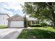 Two-car garage with brick exterior, landscaped yard, and concrete driveway at 7131 Blue Ridge Dr, Noblesville, IN 46062