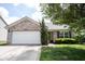 Two-car garage with brick exterior, landscaped yard, and concrete driveway at 7131 Blue Ridge Dr, Noblesville, IN 46062