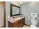 Well-lit bathroom featuring a granite vanity top, wood framed mirror, and neutral wall color at 7189 Creekwood Estates, Brownsburg, IN 46112