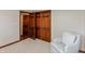 Bedroom showcasing a chair and closet with beautiful wood paneled doors at 7189 Creekwood Estates, Brownsburg, IN 46112