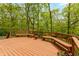 Wood deck has built in bench seating with views of the mature trees and lush greenery creating a serene outdoor experience at 7189 Creekwood Estates, Brownsburg, IN 46112