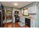 Well-lit kitchen boasts white cabinets, black appliances, and hardwood floors for a modern, functional space at 7189 Creekwood Estates, Brownsburg, IN 46112