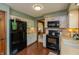 Updated kitchen showcasing white cabinets, stainless steel appliances, and hardwood floors at 7189 Creekwood Estates, Brownsburg, IN 46112