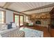 Cozy living room with a brick fireplace, beamed ceiling, and access to a deck through glass doors at 7189 Creekwood Estates, Brownsburg, IN 46112