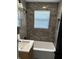 Contemporary bathroom with modern gray tiling, a sleek vanity, and a combined tub and shower for a relaxing experience at 7334 Westchester Dr, Indianapolis, IN 46226