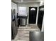 Modern kitchen featuring stainless steel appliances, sleek black cabinets, and stylish wood-look flooring at 7334 Westchester Dr, Indianapolis, IN 46226