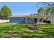 The backyard has a grass area and a fire pit near the blue sided house with a pergola covered patio at 7645 Madden Dr, Fishers, IN 46038