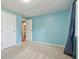 A bright bedroom offers carpet floors, blue walls, and natural light from the window at 7645 Madden Dr, Fishers, IN 46038