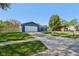 Exterior view of the home featuring a spacious driveway and a lush green lawn at 7645 Madden Dr, Fishers, IN 46038