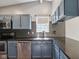 This kitchen features blue cabinets, stainless steel appliances, granite countertops, and a tile backsplash at 7645 Madden Dr, Fishers, IN 46038