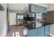 This kitchen features blue cabinets, stainless steel appliances, granite countertops, and a tile backsplash at 7645 Madden Dr, Fishers, IN 46038