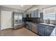 This kitchen features blue cabinets, stainless steel appliances, granite countertops, and tile backsplash at 7645 Madden Dr, Fishers, IN 46038