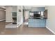 Open concept living room and kitchen featuring fireplace, blue cabinets, and stainless steel appliances at 7645 Madden Dr, Fishers, IN 46038
