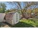 Small backyard storage shed with a gabled roof and a single entry door on a small lawn at 7645 Madden Dr, Fishers, IN 46038