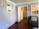 Living room with hardwood floors, modern furniture, an opening looking into the hall, and light blue walls at 7764 Hollybrook Ln, Southport, IN 46227