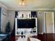 Living room with a ceiling fan, hardwood floors, a large window, and a decorative entertainment center at 7764 Hollybrook Ln, Southport, IN 46227