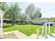 Landscaped backyard with healthy green grass, mature trees, and chain link fence at 7849 E 49Th St, Indianapolis, IN 46226