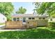 Charming home featuring a cozy front deck, stone accents, and a well-maintained lawn at 7849 E 49Th St, Indianapolis, IN 46226