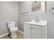 Bright bathroom featuring a white vanity, toilet, mirror, and wood-look flooring at 807 Vasbinder Dr, Chesterfield, IN 46017