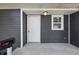 Close-up of the front porch showcasing the entrance door, house number, a light fixture, and gray horizontal siding at 807 Vasbinder Dr, Chesterfield, IN 46017