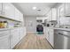 Modern kitchen with white cabinets, stainless steel appliances, and new flooring, providing a clean and updated look at 807 Vasbinder Dr, Chesterfield, IN 46017