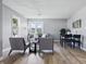 Spacious living room featuring modern chairs, a sofa, a dining table, and large windows for ample natural light at 807 Vasbinder Dr, Chesterfield, IN 46017