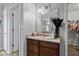 This bathroom features a large mirror, wood cabinets, a sink, and a doorway to a closet at 8178 Eskerban Dr, Avon, IN 46123