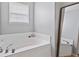 Corner bathtub with chrome fixtures and a window providing natural light at 8178 Eskerban Dr, Avon, IN 46123