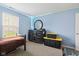 Neutral carpeted bedroom with blue walls, window, Craftsman storage containers, and black dresser with round mirror at 8178 Eskerban Dr, Avon, IN 46123