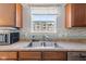 Kitchen sink with stainless appliances, ample wood cabinets, decorative tile backsplash, and a window for natural light at 8178 Eskerban Dr, Avon, IN 46123