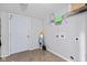 Neutral laundry room with overhead shelf, tile floor, and white utility door at 8178 Eskerban Dr, Avon, IN 46123