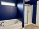 A blue bathroom features a tub and a separate glass shower at 837 Sommersweet Run, Greenwood, IN 46143