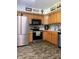 Well-lit kitchen features stainless steel appliances, wood cabinetry, and dark stone-look flooring at , Martinsville, IN 46151