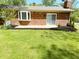 Brick home with bay window and sliding glass door to backyard patio surrounded by landscaping at 8835 Briarclift Rd, Indianapolis, IN 46256