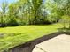 Landscaped backyard with a patio, garden bed, and a lush lawn, providing a serene outdoor space at 8835 Briarclift Rd, Indianapolis, IN 46256