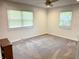 Spacious bedroom with neutral carpet, two windows, and a ceiling fan at 8835 Briarclift Rd, Indianapolis, IN 46256