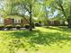 A charming brick home with a well-manicured lawn and mature trees, creating a welcoming atmosphere at 8835 Briarclift Rd, Indianapolis, IN 46256