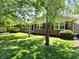 Well-maintained lawn and landscaping surround this charming brick home with a covered porch at 8835 Briarclift Rd, Indianapolis, IN 46256