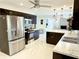 Open concept kitchen with stainless appliances, stone backsplash, and dark cabinets at 8835 Briarclift Rd, Indianapolis, IN 46256