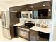 Modern kitchen with stainless appliances, stone backsplash, and white countertops at 8835 Briarclift Rd, Indianapolis, IN 46256