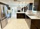 Modern kitchen with stainless appliances, stone backsplash, and dark cabinets at 8835 Briarclift Rd, Indianapolis, IN 46256