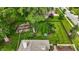 An aerial view showcases a beautifully landscaped backyard with patio, lush lawn, mature trees, and manicured garden beds at 8905 Stonebriar Dr, Indianapolis, IN 46259